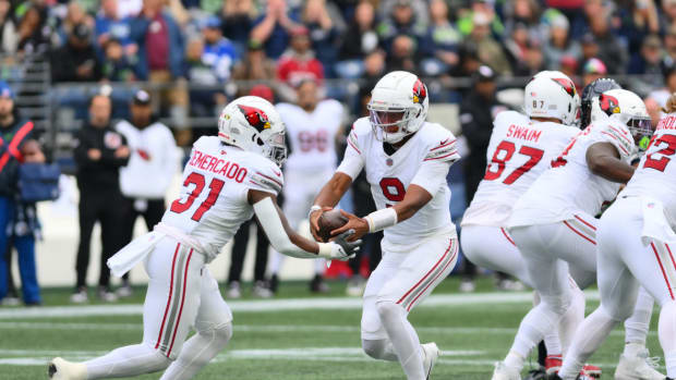 Arizona Cardinals quarterback Joshua Dobbs (9) hands the ball to Arizona Cardinals running back Emari Demercado (31) during the first half against the Seattle Seahawks at Lumen Field.